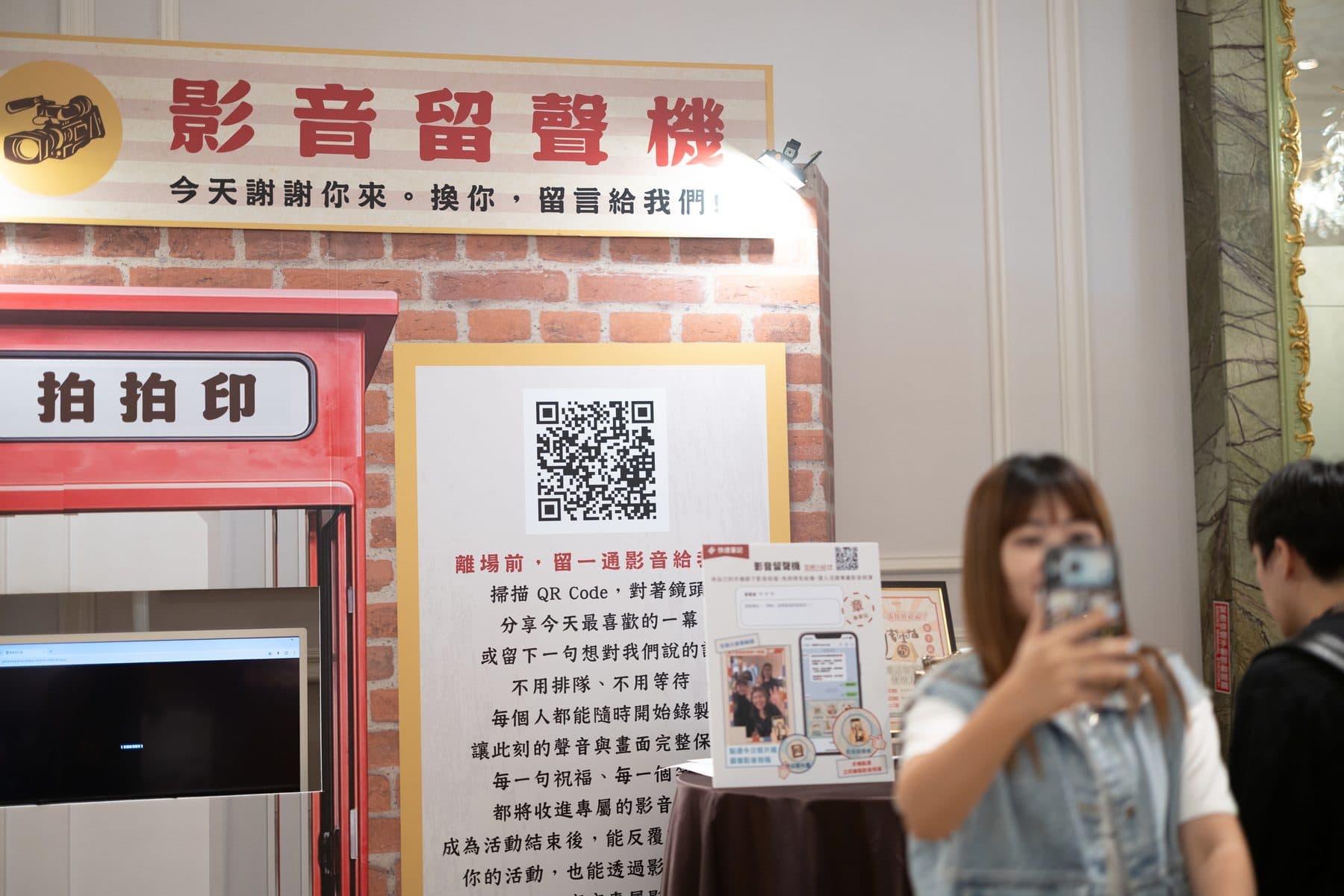 影音留聲機展區，紅色復古電話亭造型攤位，牆上有 QR Code 與錄影留言的說明文案