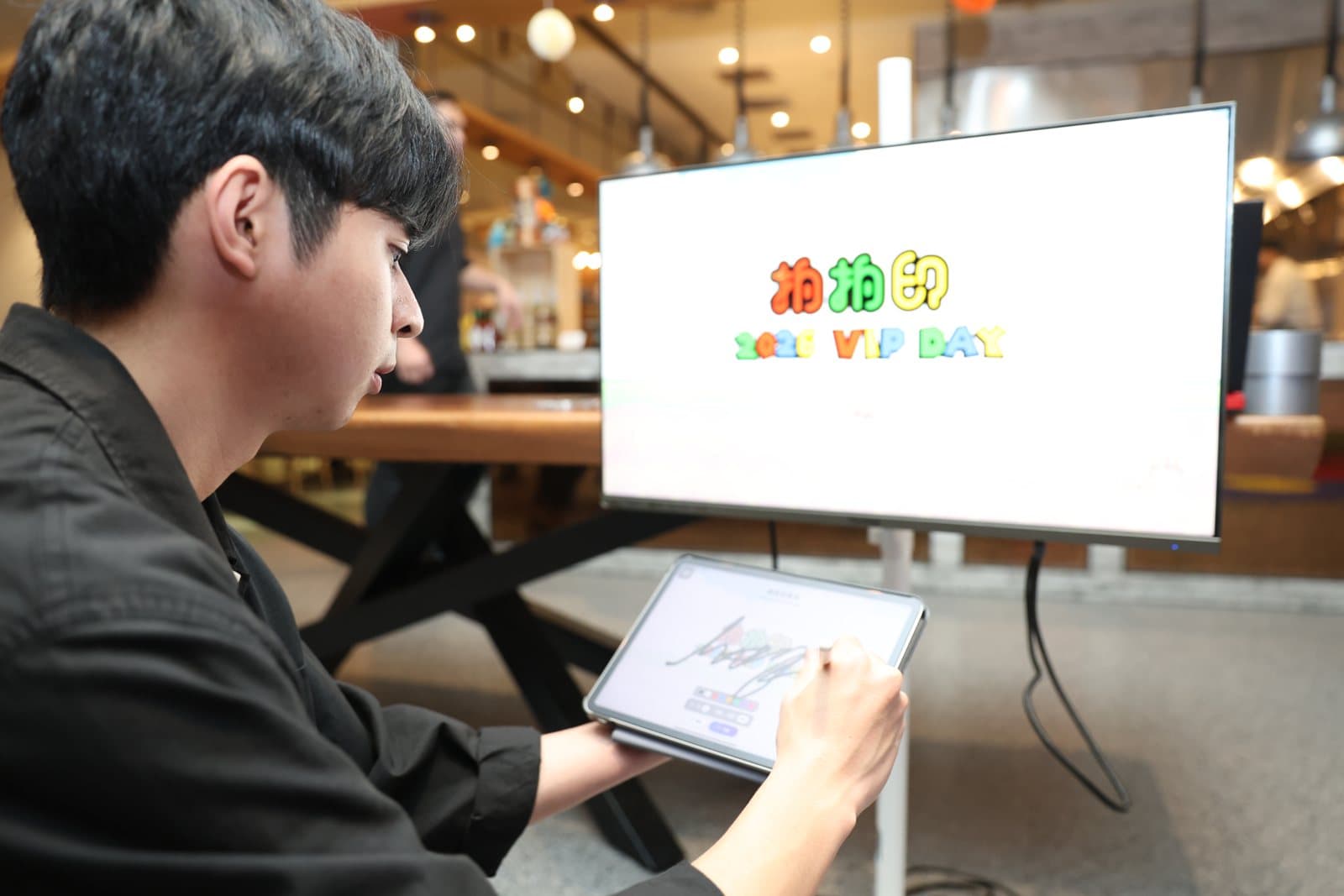 賓客在平板上手寫簽名,筆跡同步上大螢幕