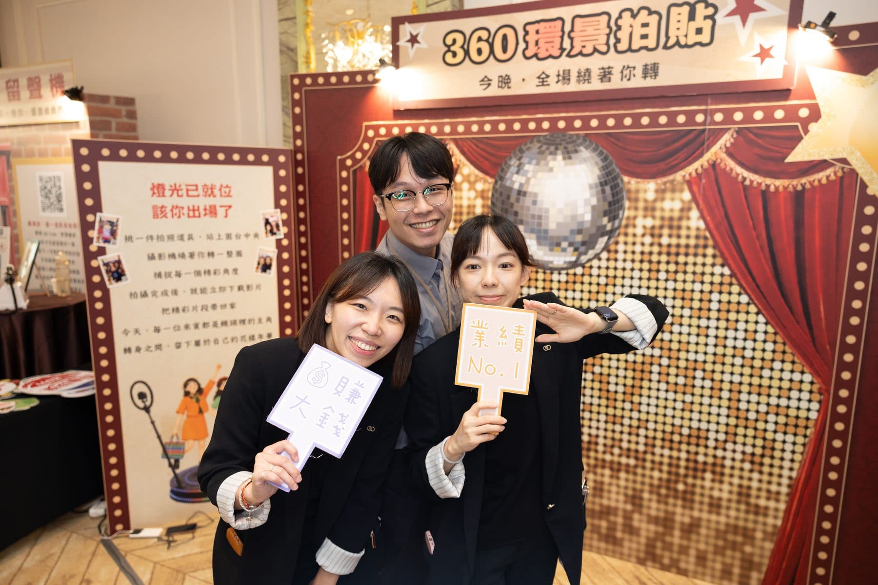 三位賓客在 360 環景拍貼區前手持發光手舉牌合影,背景為復古戲院風格背板