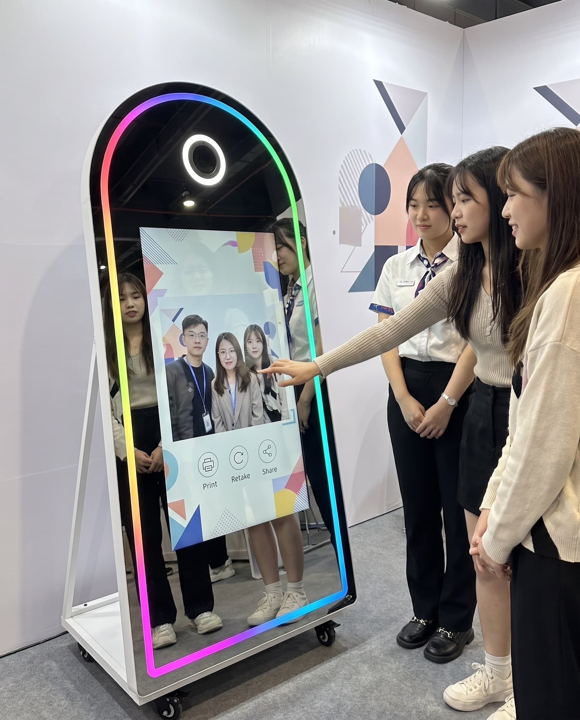 品牌發表會展場,賓客與品牌人員在魔鏡拍貼機前互動拍照